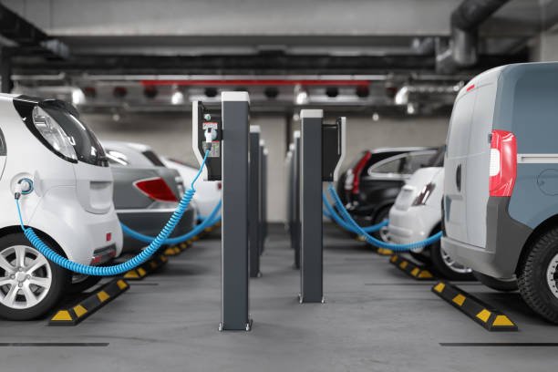 side view of charging electric cars in parking garage. clean energy concept